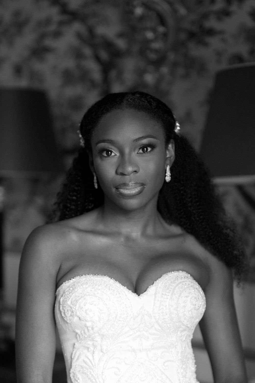 Close-up portrait of person wearing strapless white wedding gown with delicate lace details.