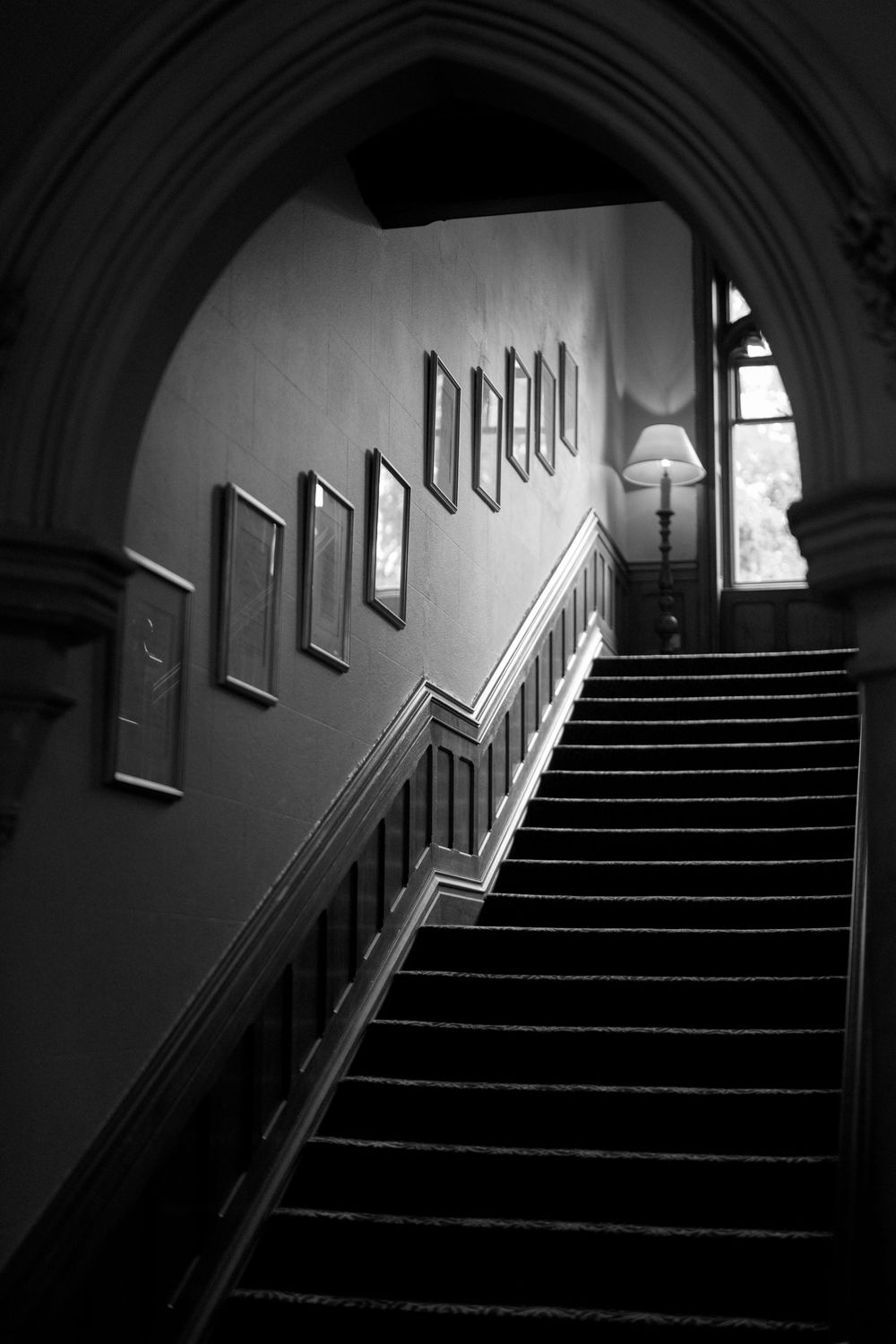 Dark moody staircase with dramatic lighting and shadows leading upwards.