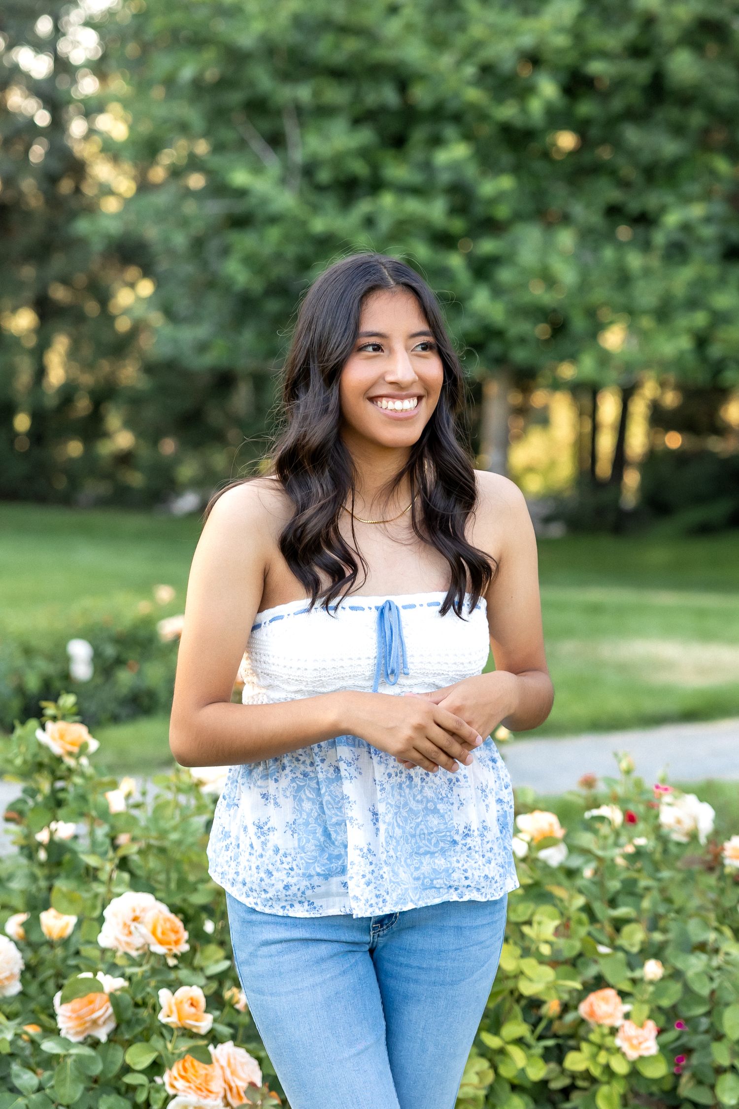 A series of outdoor portrait photos taken in a garden with blooming roses during golden hour lighting.