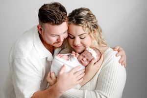 A collection of intimate family portraits in soft neutral tones showing tender moments with a newborn baby.