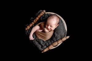 Black and white newborn photography artistic silhouettes with gentle shadows and dramatic lighting effects.