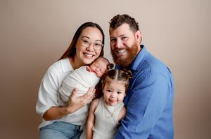A loving family shares tender moments together in a series of warm, neutral-toned studio portrait photographs.