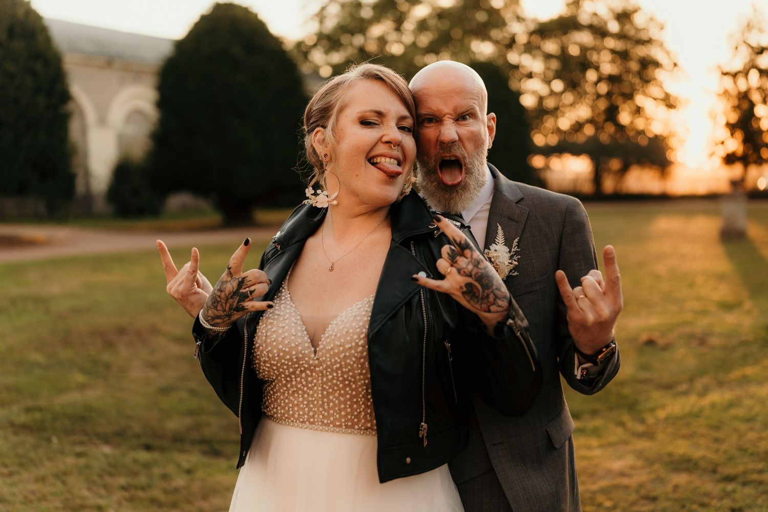 A couple shares a joyful moment together during golden hour sunset in a grassy field.