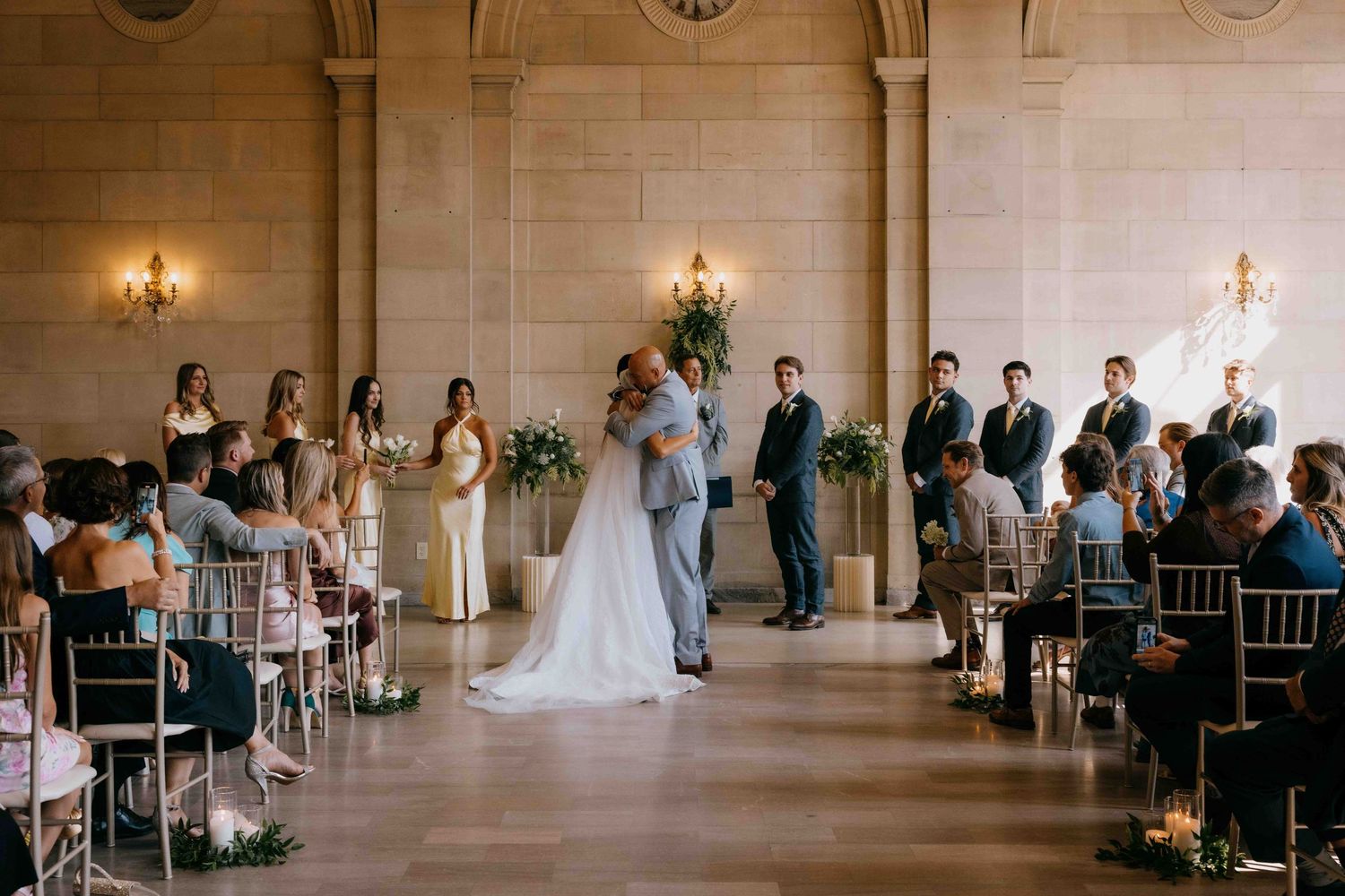 A bride and her dad hugging during the wedding ceremony before giving her to the groom.