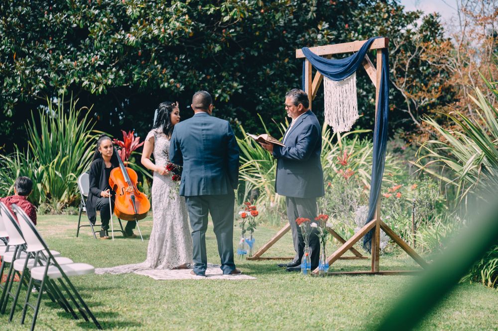 Wide angle view of outdoor wedding ceremony with guests and natural surroundings.