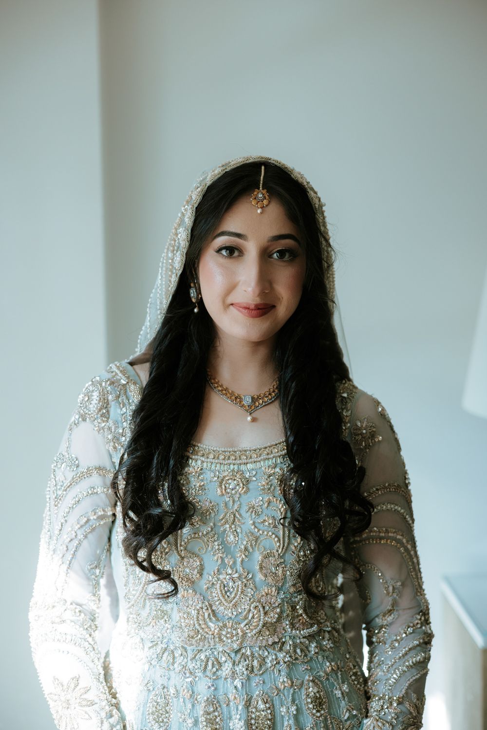 A series of close-up portraits showcasing intricate white and silver South Asian bridal attire with delicate embellishments.