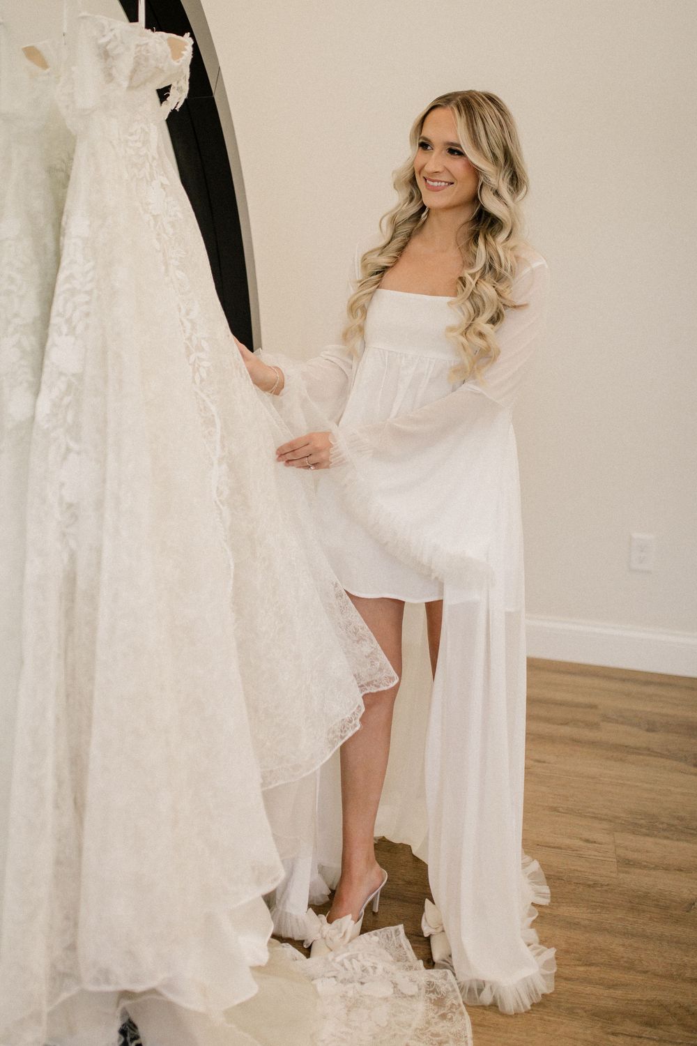 Elegant white wedding dress with lace details displayed in a bridal suite.