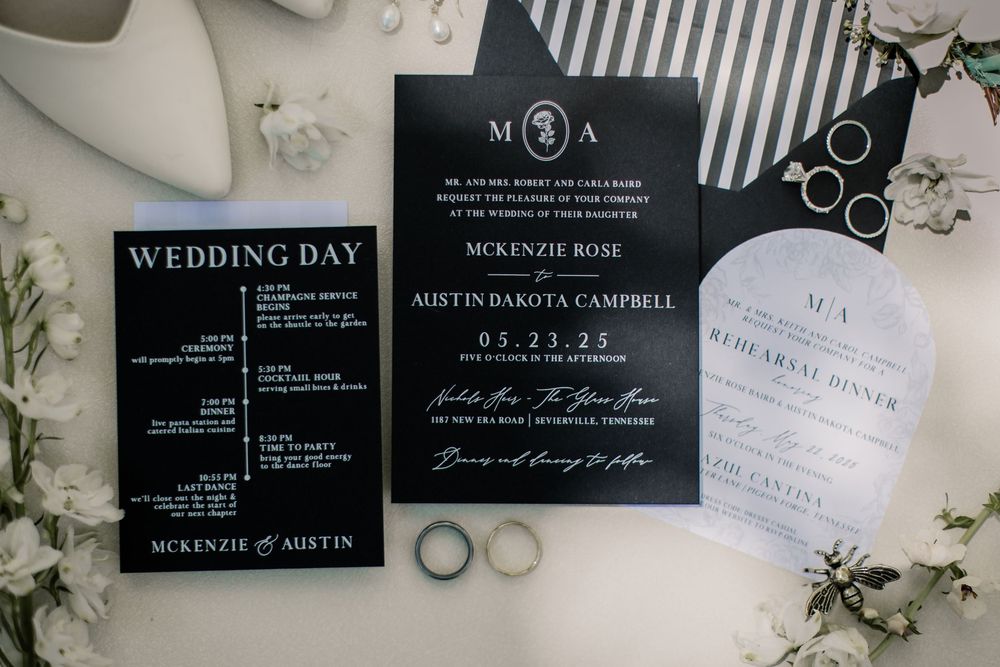 Elegant black and white wedding invitations with floral accents and modern typography.