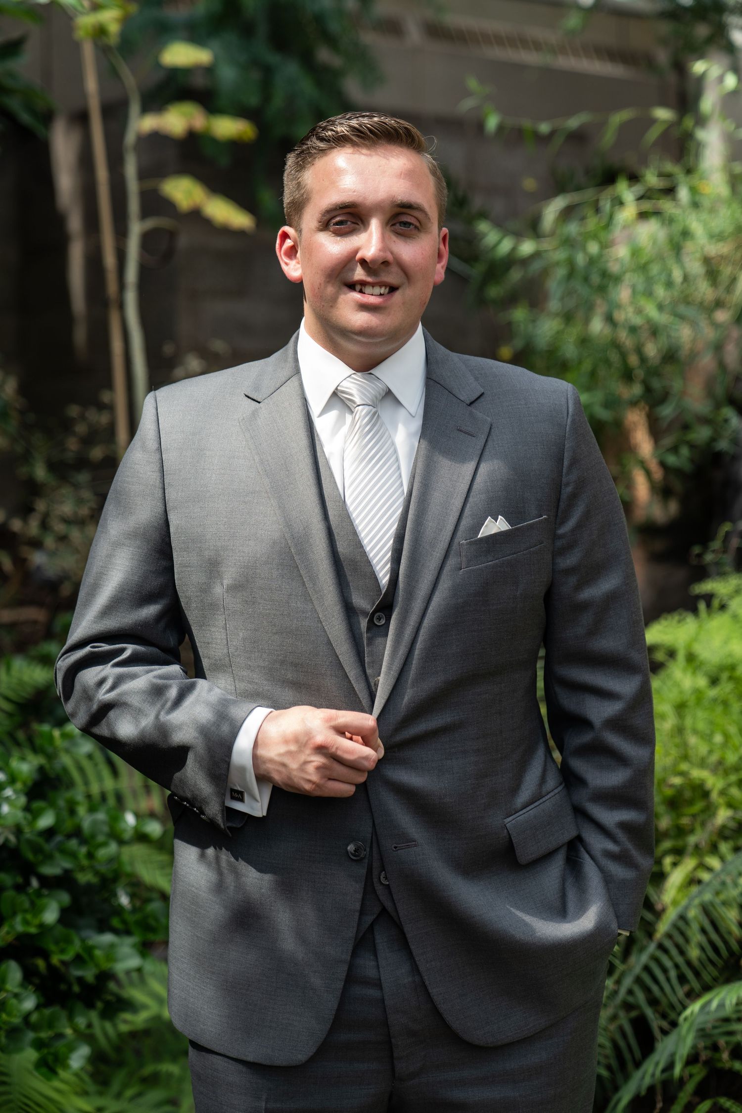 Personal Brand Portrait of an executive in a fancy suit in front of plants.