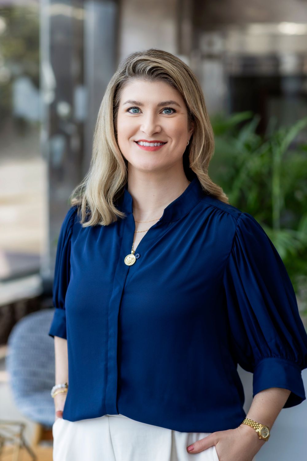 A person wearing a navy blue button-up blouse with puff sleeves shown from different angles in a photo series.