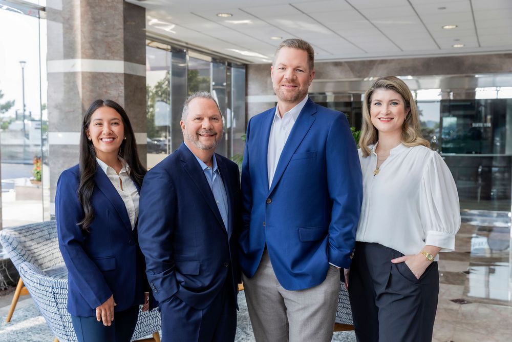 Professional business team in navy suits stands together in modern office lobby.