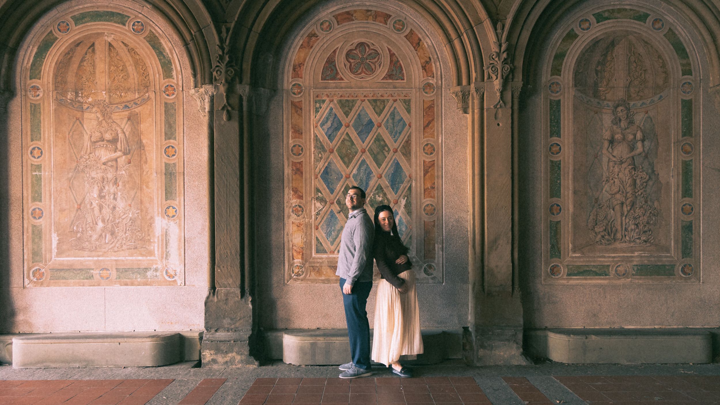 A panoramic view of ornate Gothic stone carvings and archways in a historic cathedral corridor.