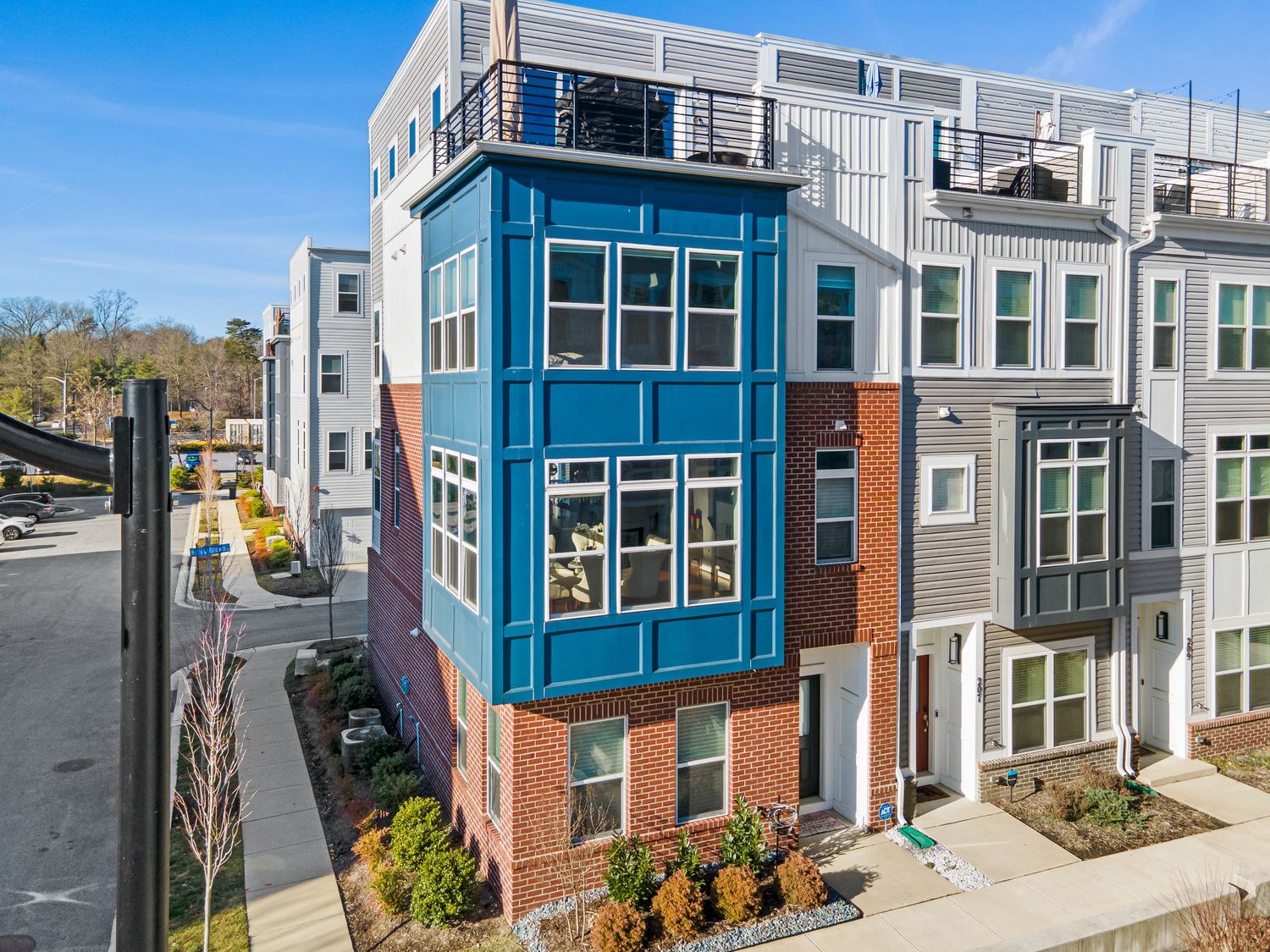 Row of modern townhouses with blue and gray exterior finishes and contemporary architectural design.