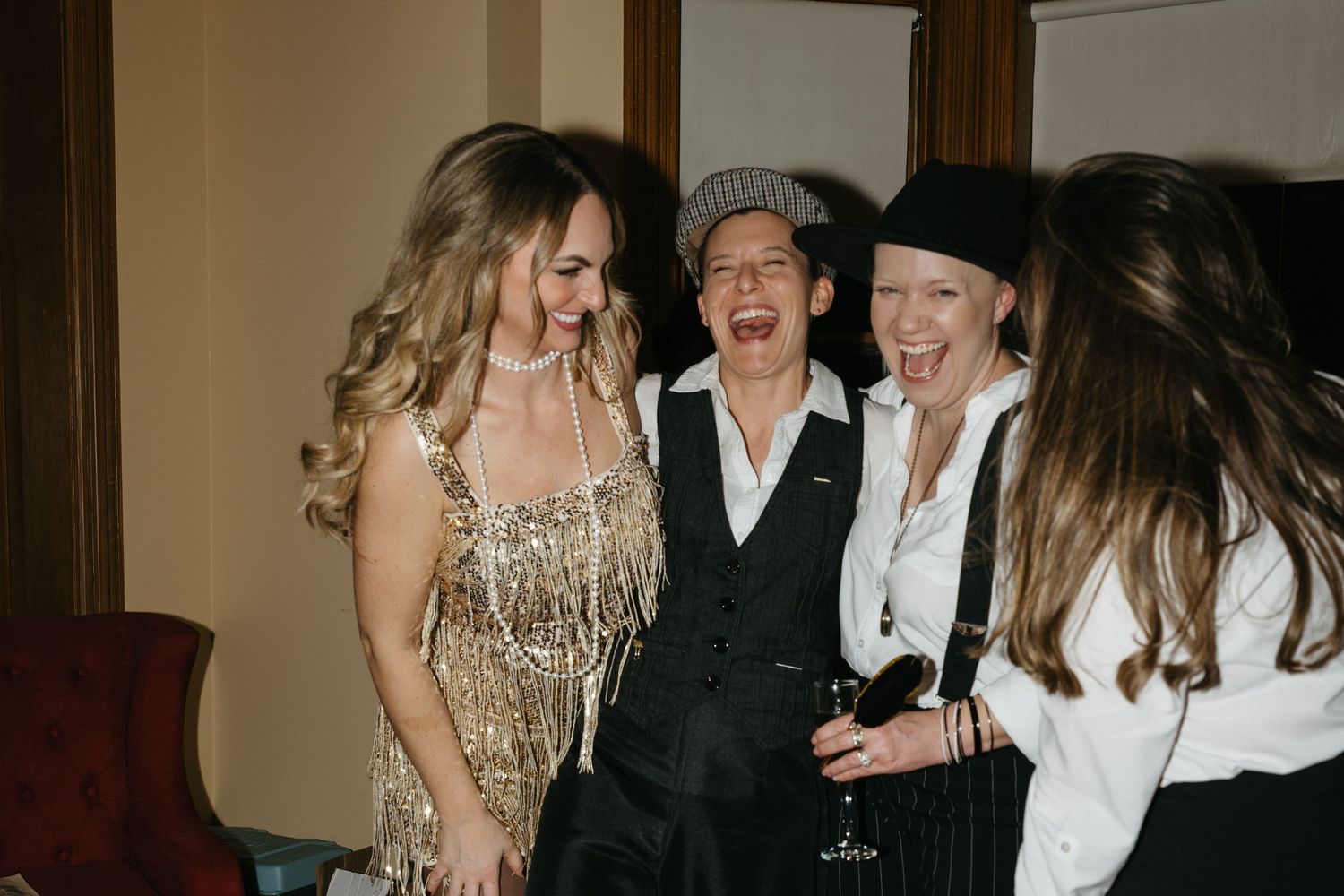 A group of people in formal attire pose together at an indoor event.