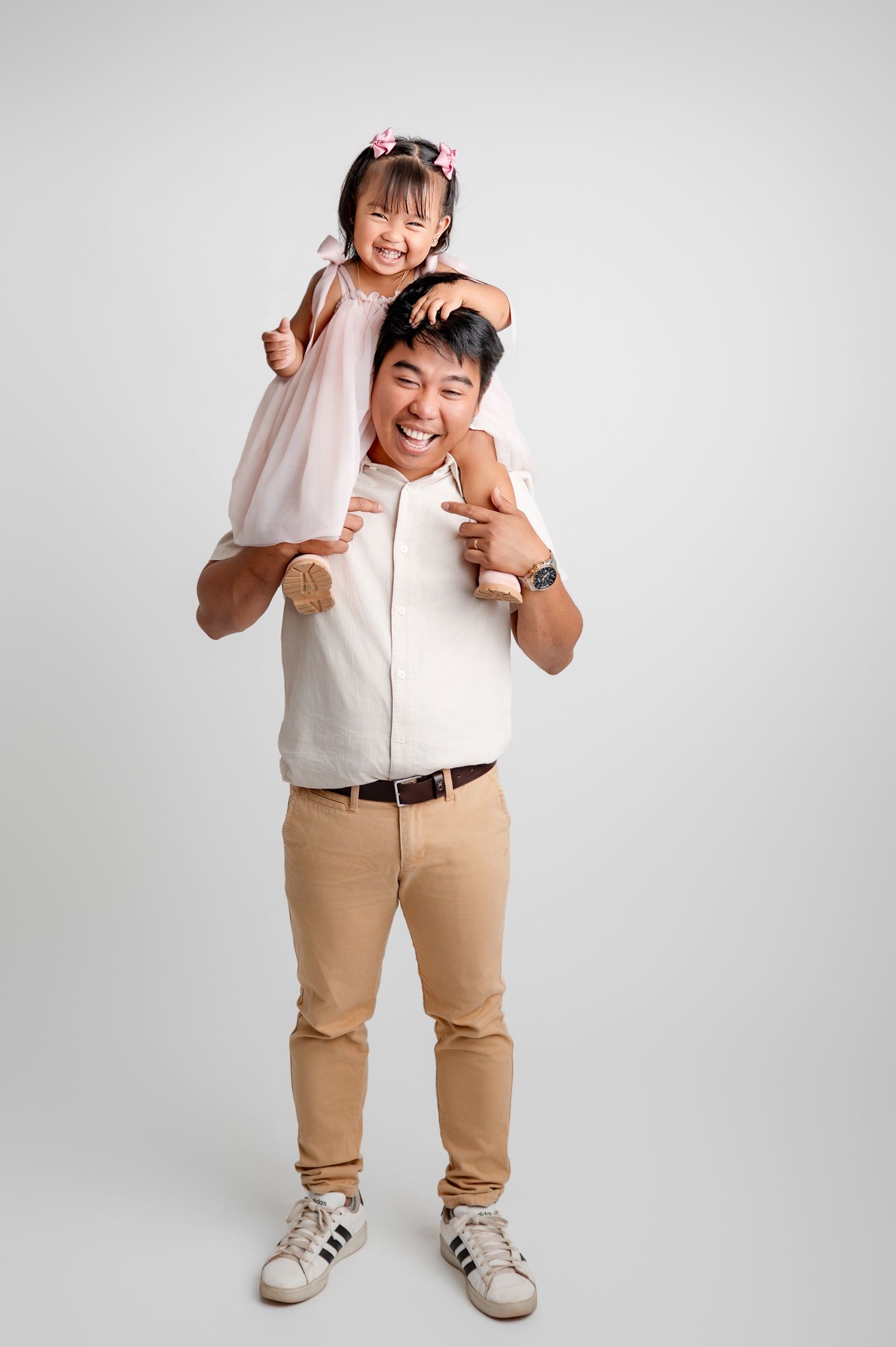 Person in white shirt and khaki pants strikes playful fighting poses in sequence against white background.