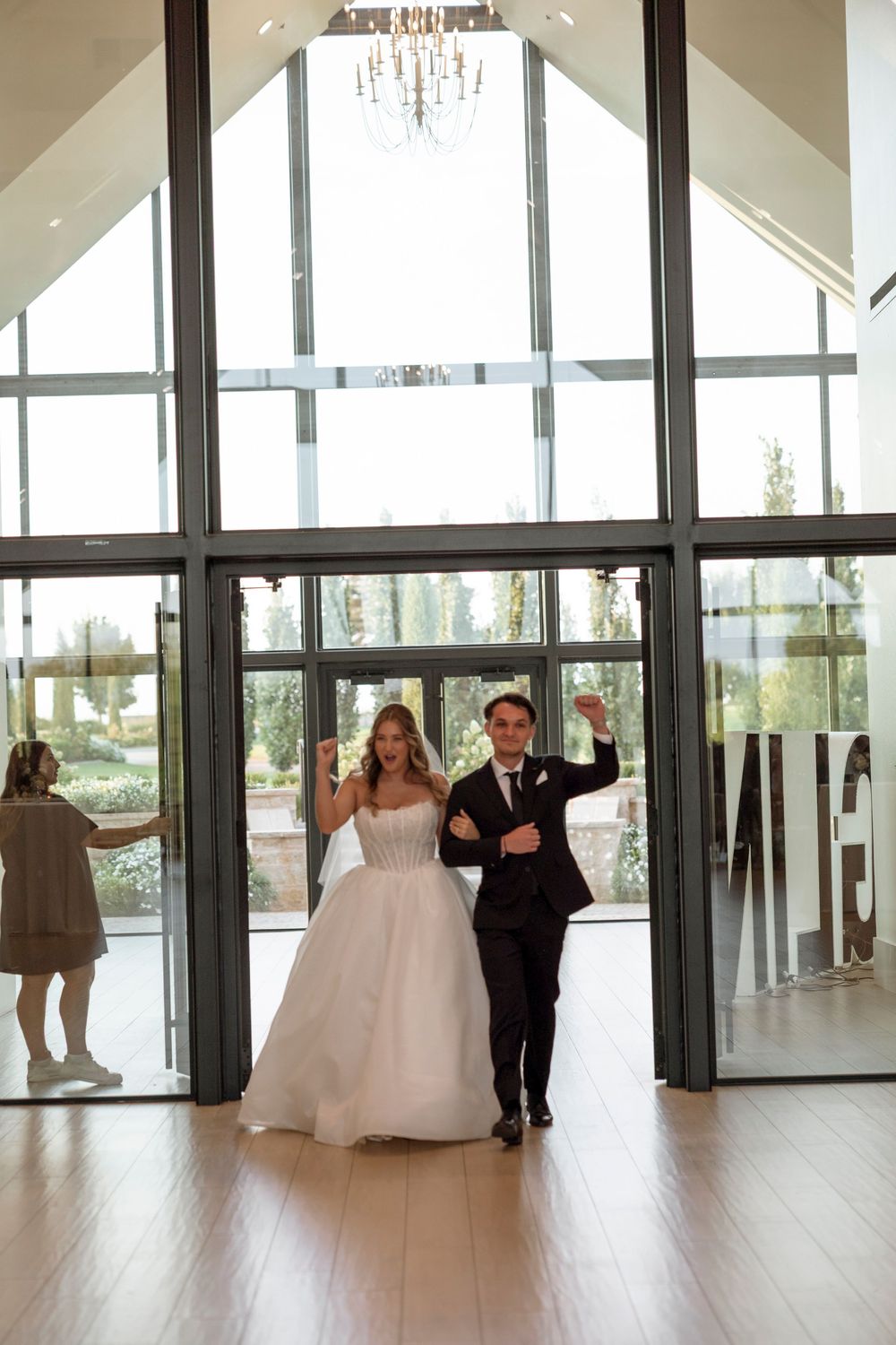 Modern wedding venue with floor-to-ceiling windows and natural light streaming in.