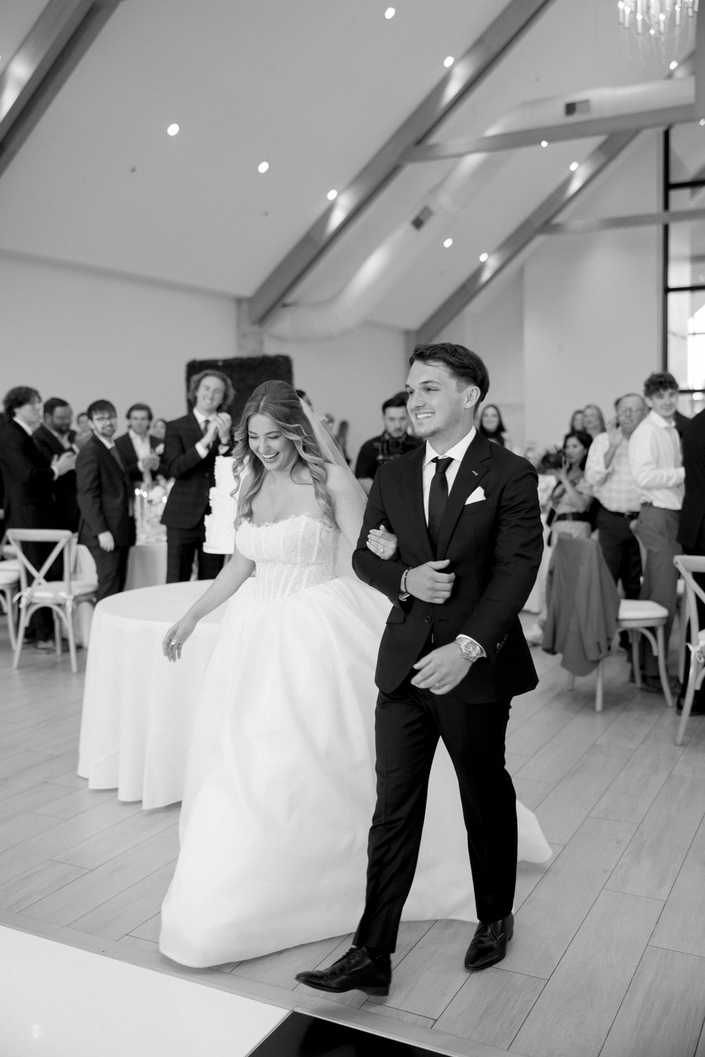 Couple dancing together during their wedding celebration in an elegant white venue.