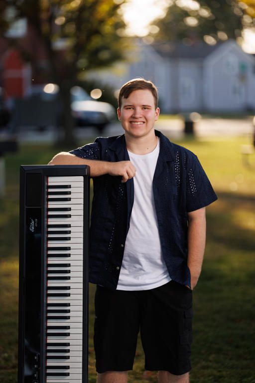 Portrait series of someone in a white shirt and dark jacket posing with a piano keyboard outdoors at sunset.