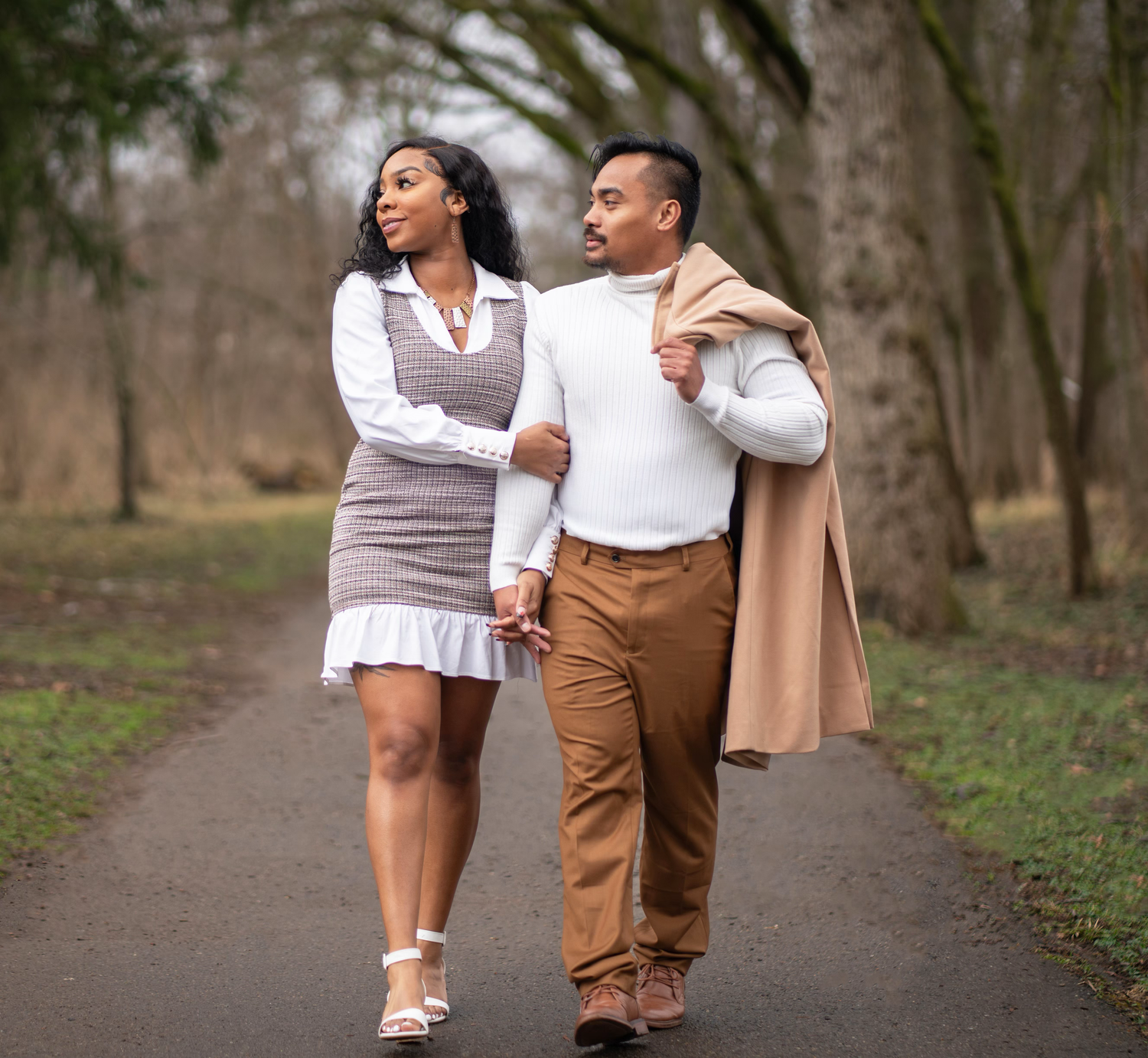 An engaged couple takes a romantic walk together for a photo
