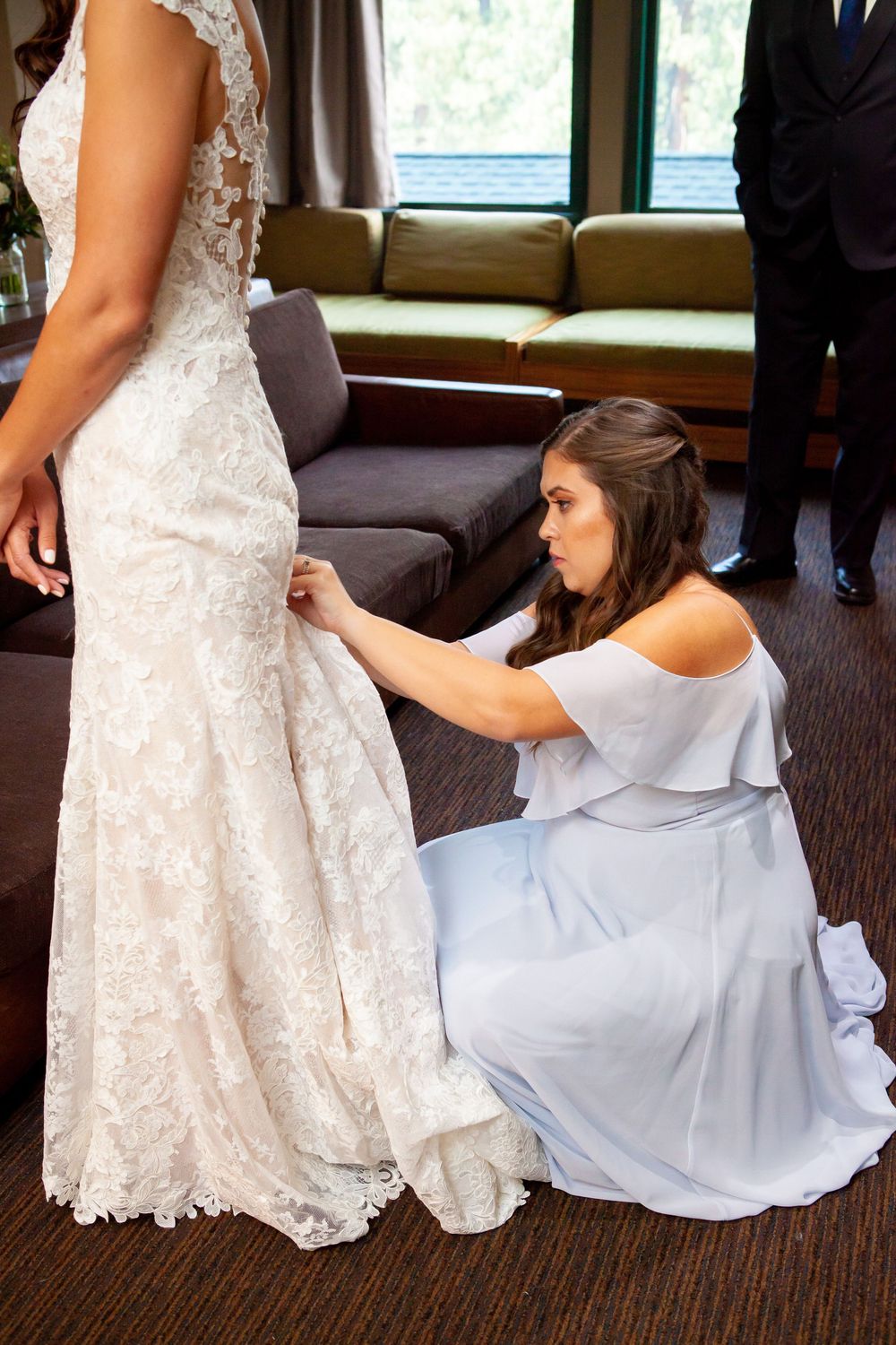 A series of photos showing detailed adjustments being made to a white lace wedding dress train on carpeted floor.