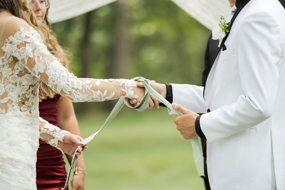 Close-up of couple exchanging vows during outdoor wedding ceremony.