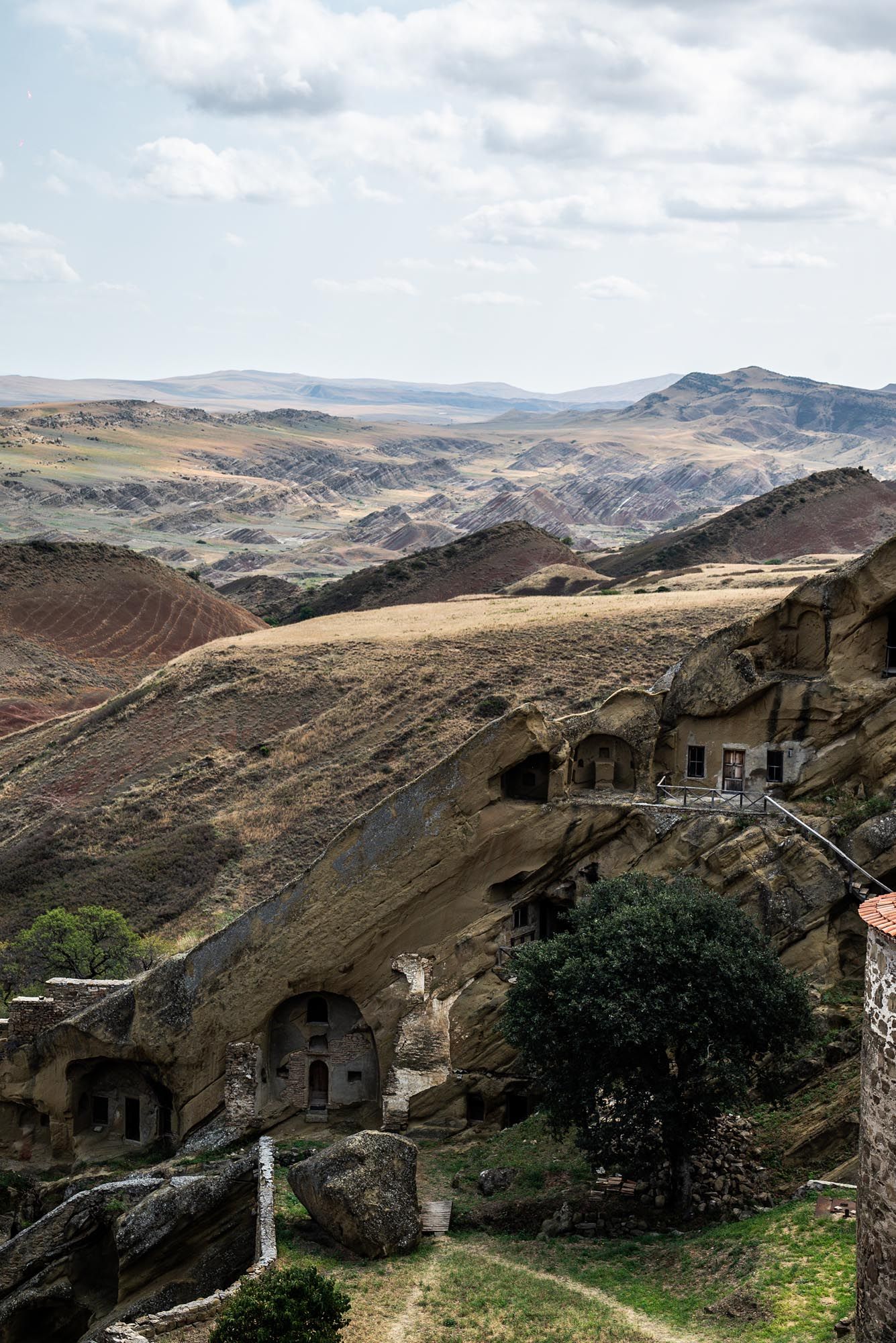 Scenic views of rugged mountain landscapes with ancient stone buildings nestled among steep cliffs in a remote valley.