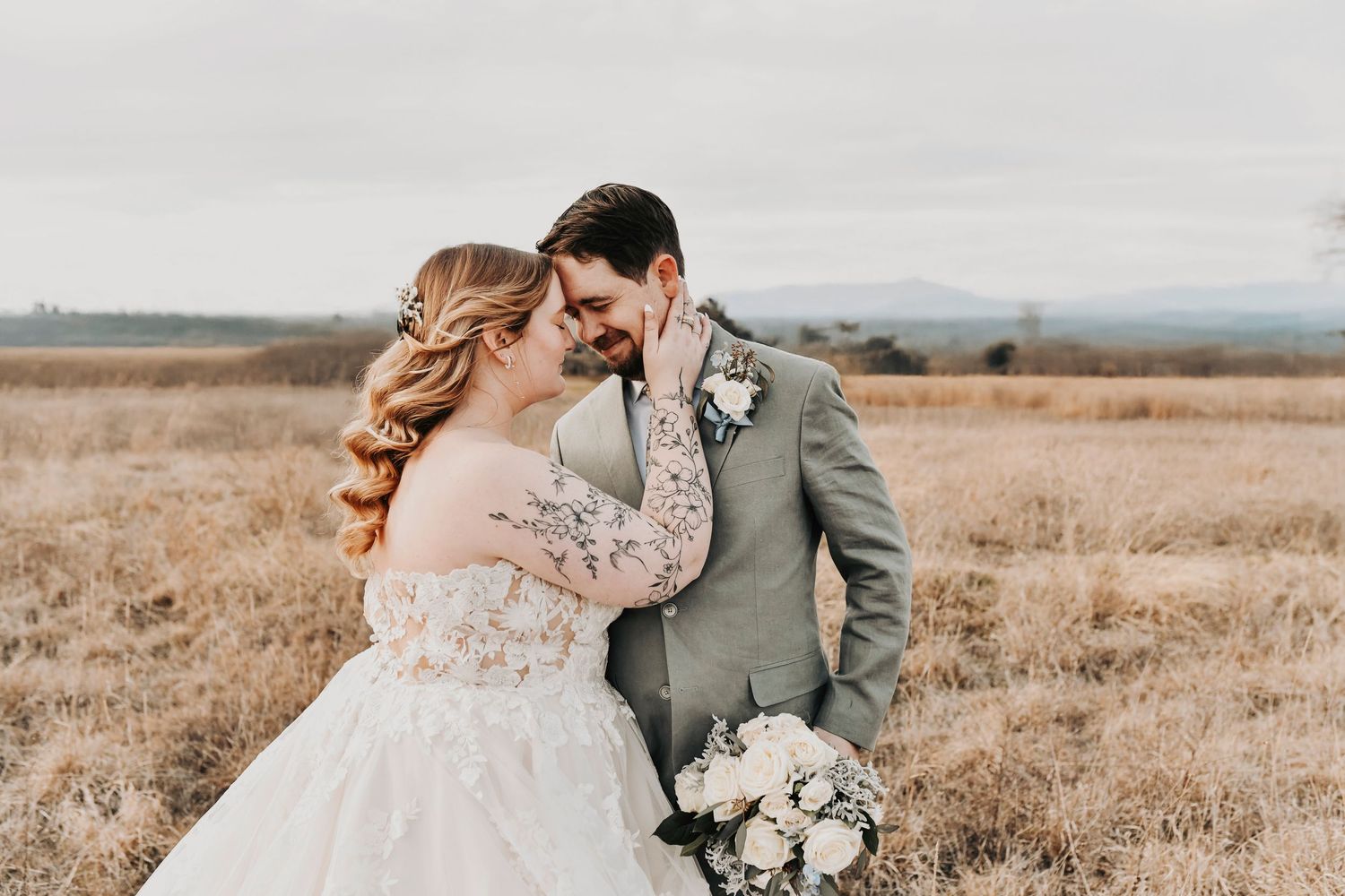 Editorial wedding portrait of couple at sunset with cloudy sky and soft winter light