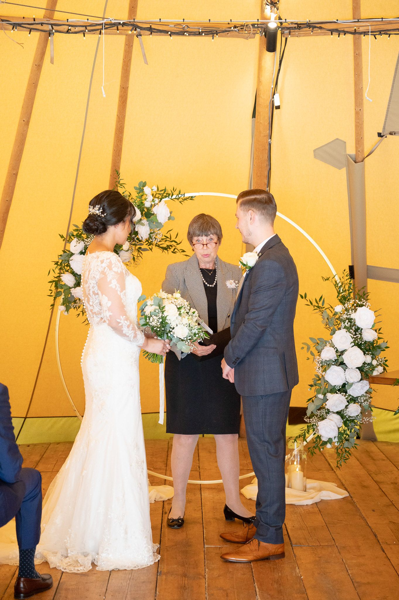 Wedding ceremony sequence inside a warm-lit tipi tent with floral decorations and wooden flooring.