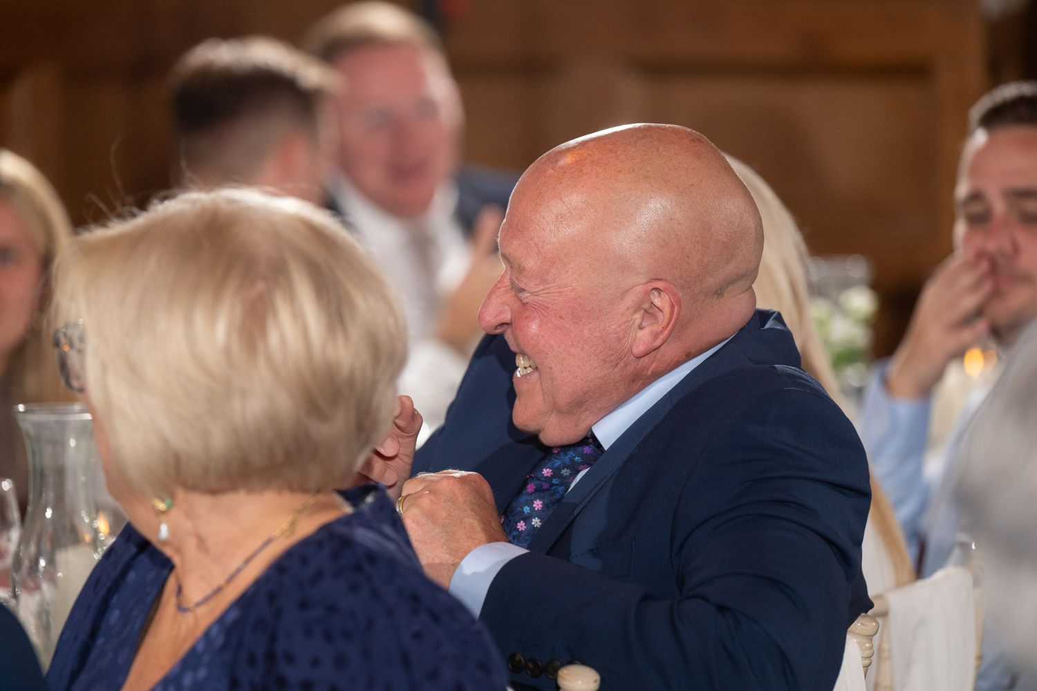 People gathered in formal attire at what appears to be a wedding reception or banquet event.