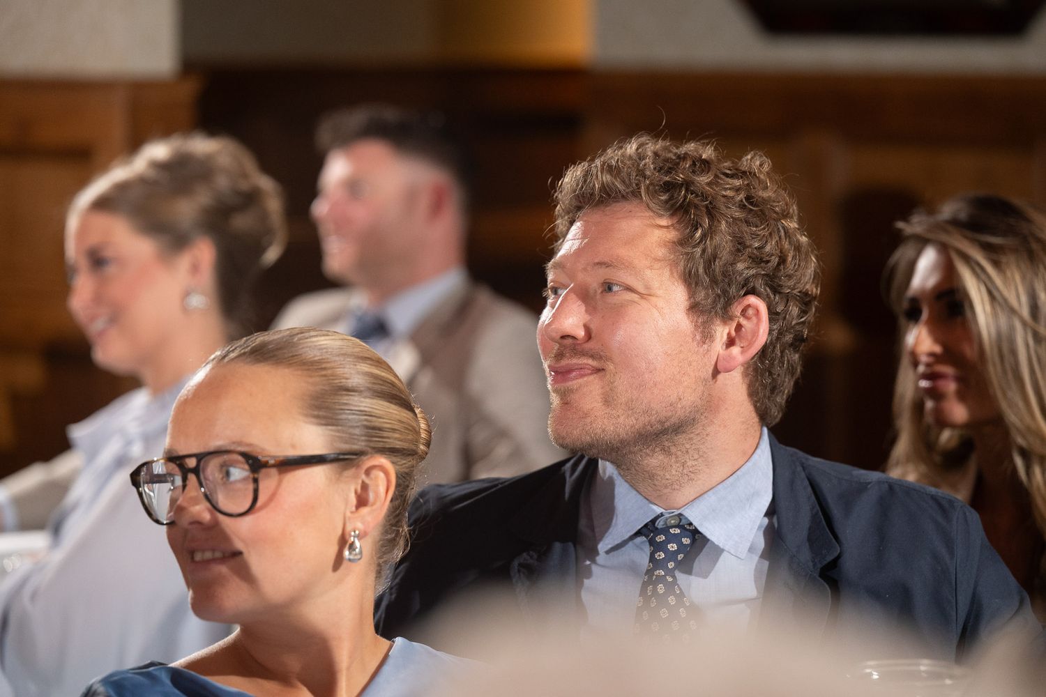 A group of business professionals networking and mingling at a corporate event in an indoor venue.