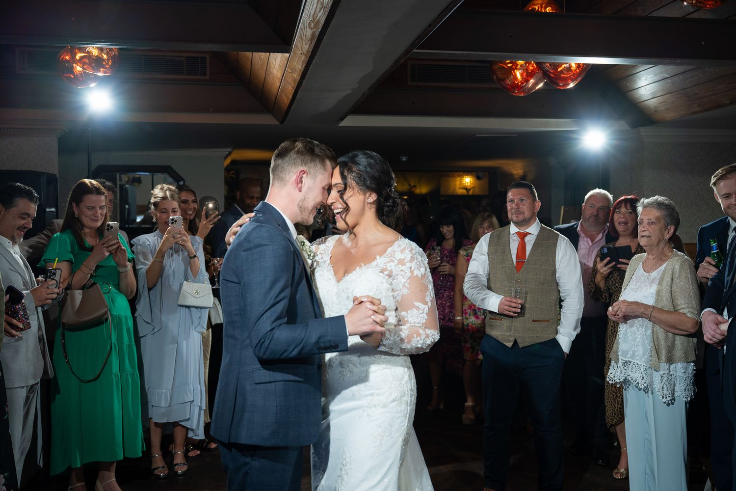 Couples dancing together at an elegant evening wedding reception with warm lighting and festive atmosphere.