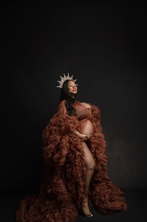 Artistic maternity photo series showing a pregnant figure in brown tulle gown and crown against dark background.