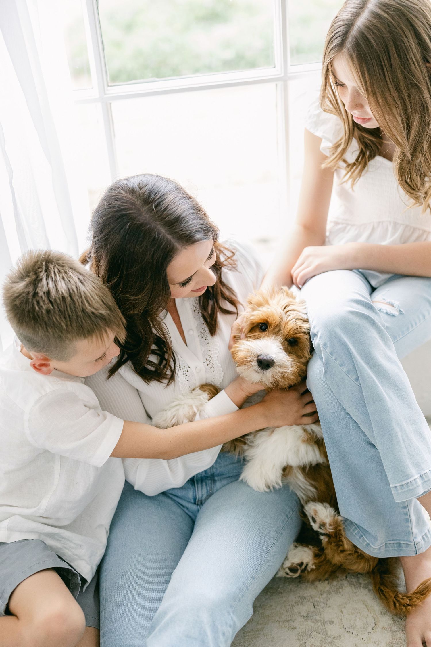 Playful family portrait with children laughing on a white bed during a Northern Virginia family photography session.