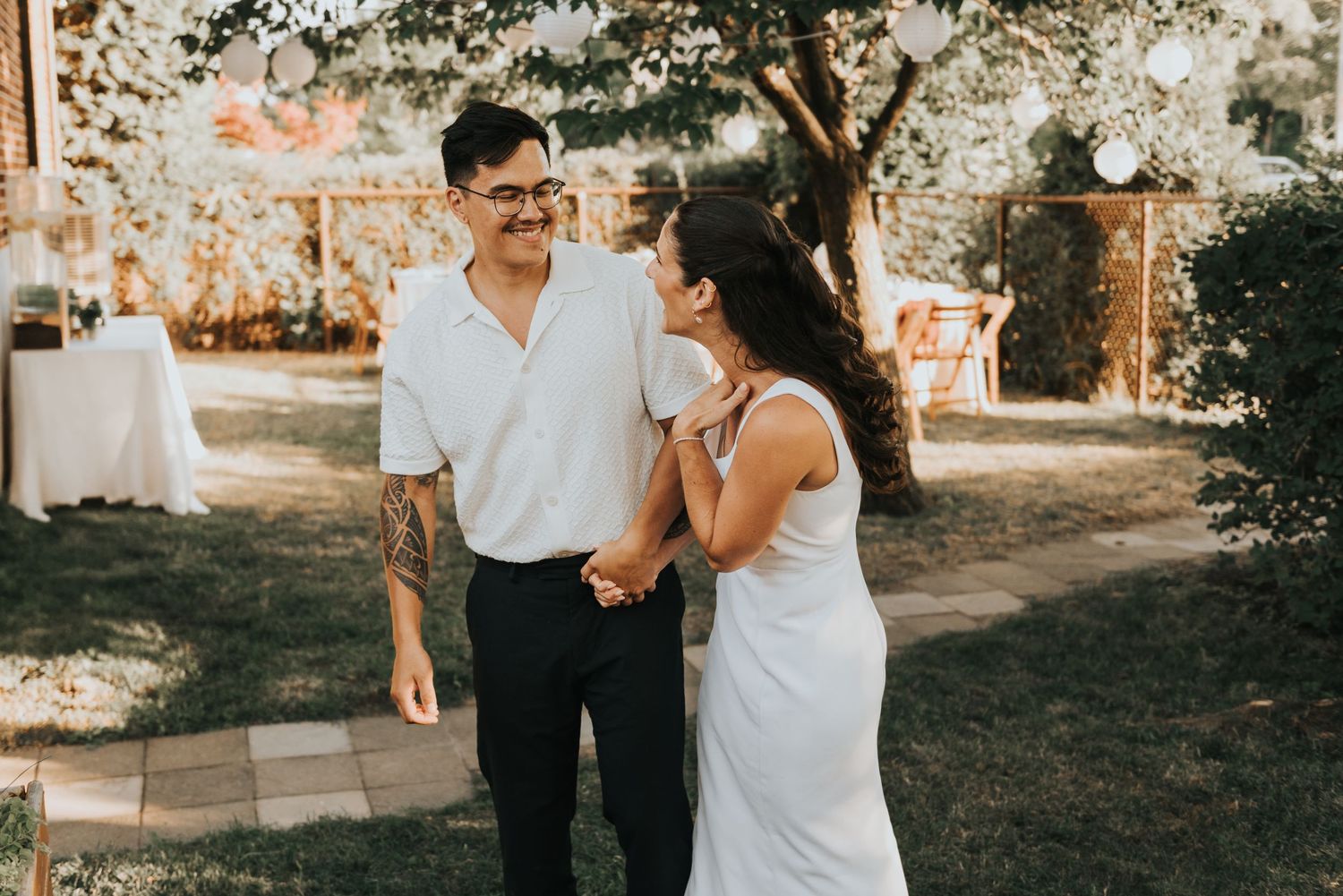 A couple shares an intimate moment during a rustic outdoor wedding photo session in a garden setting.