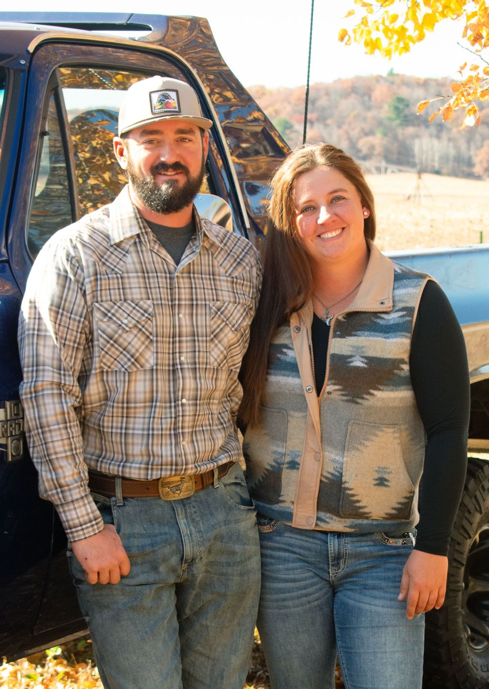 Boyfriend and girlfriend smiling in front of a 1984 Chevy Square body.
