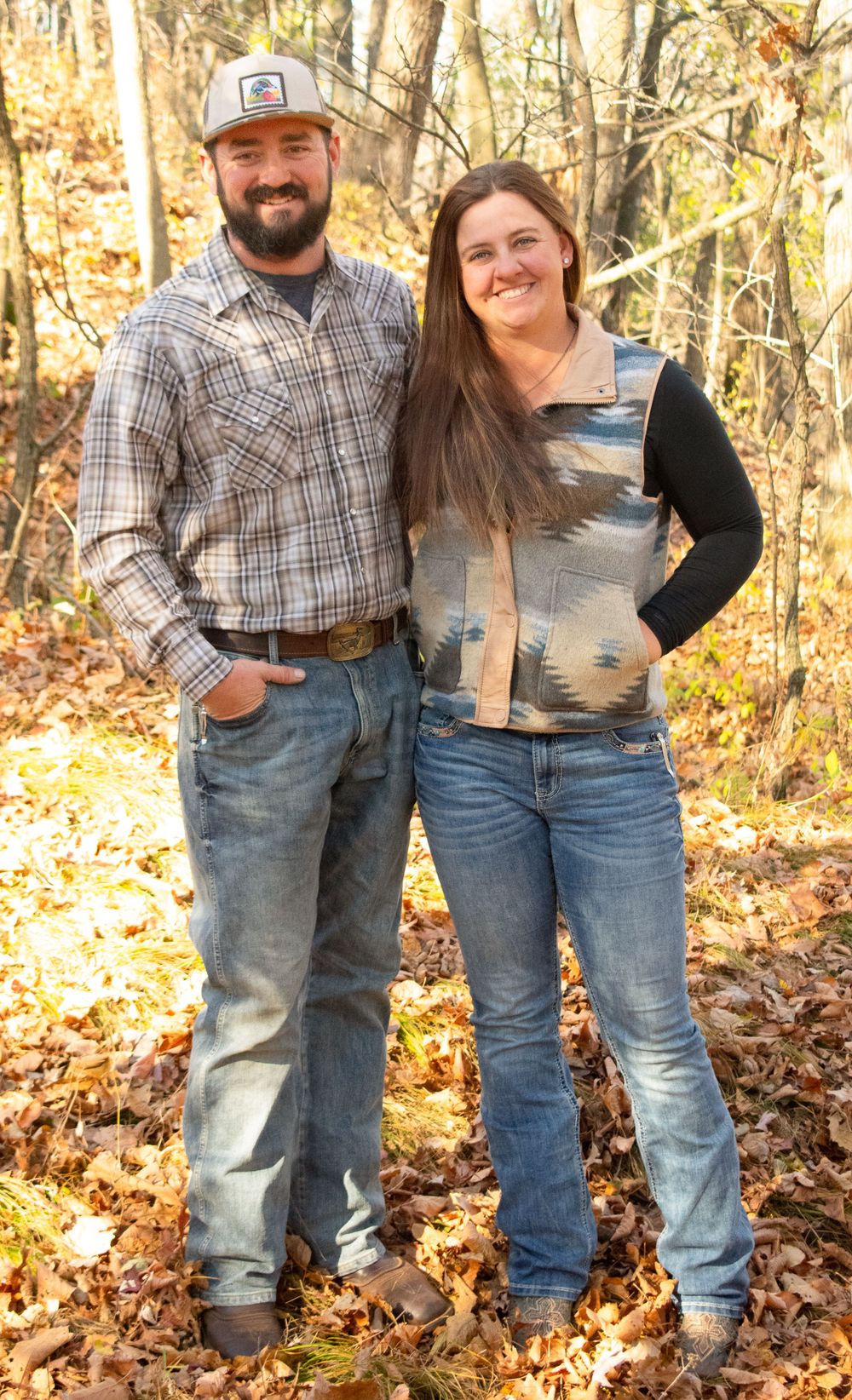 Boyfriend and girlfriend standing together in the woods.
