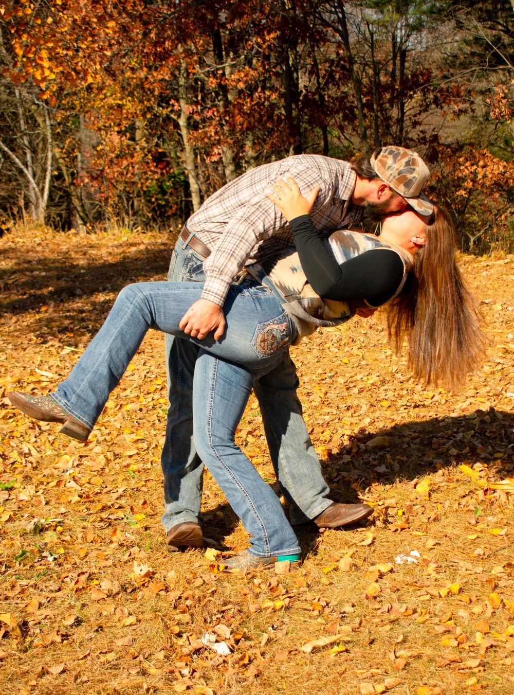 Boyfriend dipping girlfriend for a kiss in front of the Wisconsin fall colors.