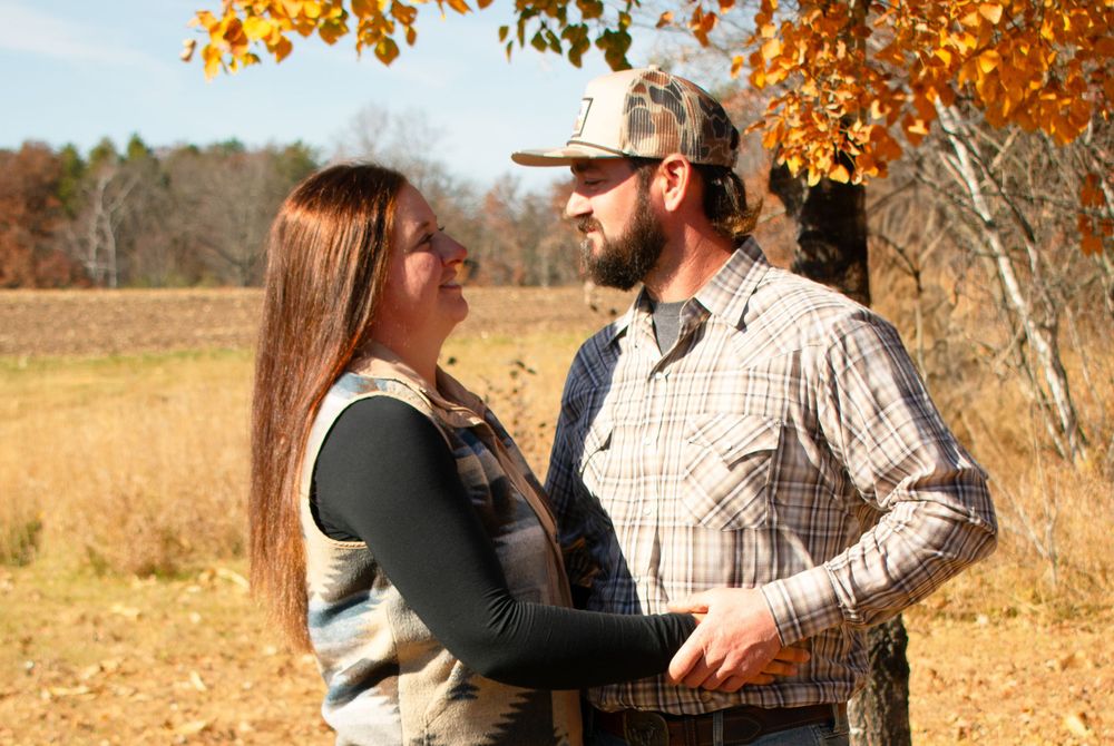 Boyfriend and girlfriend looking lovingly at each other  in front of the Wisconsin fall colors.