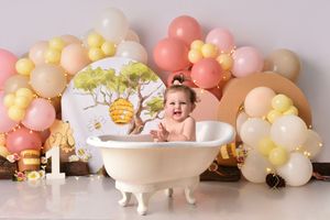 Pastel balloon arch installation with soft pink, yellow and peach colors creates a dreamy backdrop for baby photography.