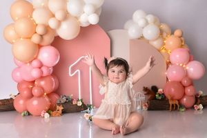 Peach and pink balloon arch setup for first birthday photo session.
