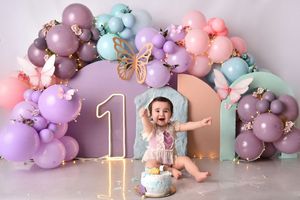 Pastel balloon garland decorations in pink, purple, and mint green colors create a whimsical party setting.