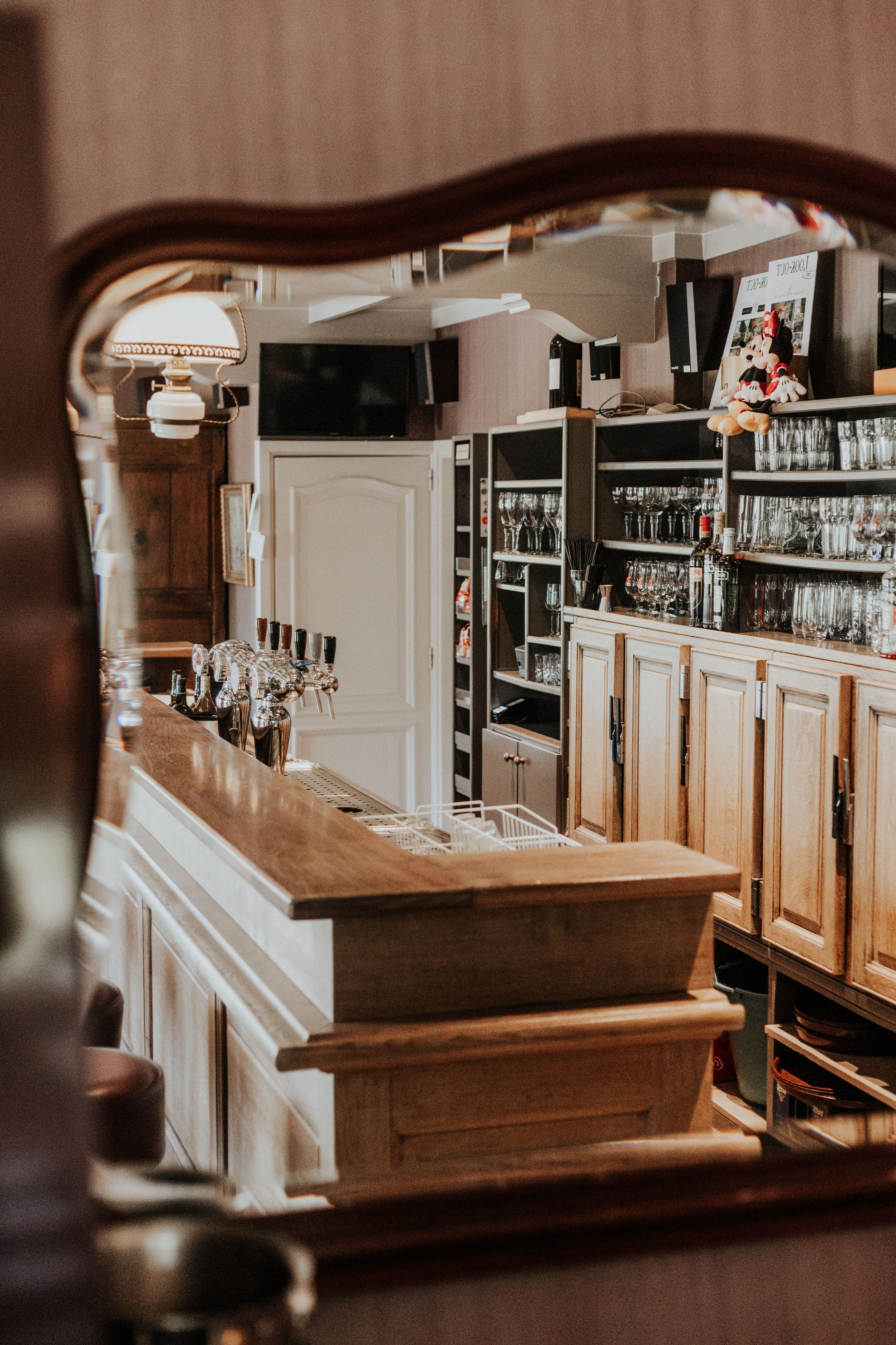 Classic wooden bar counter with traditional cabinetry and glass storage.