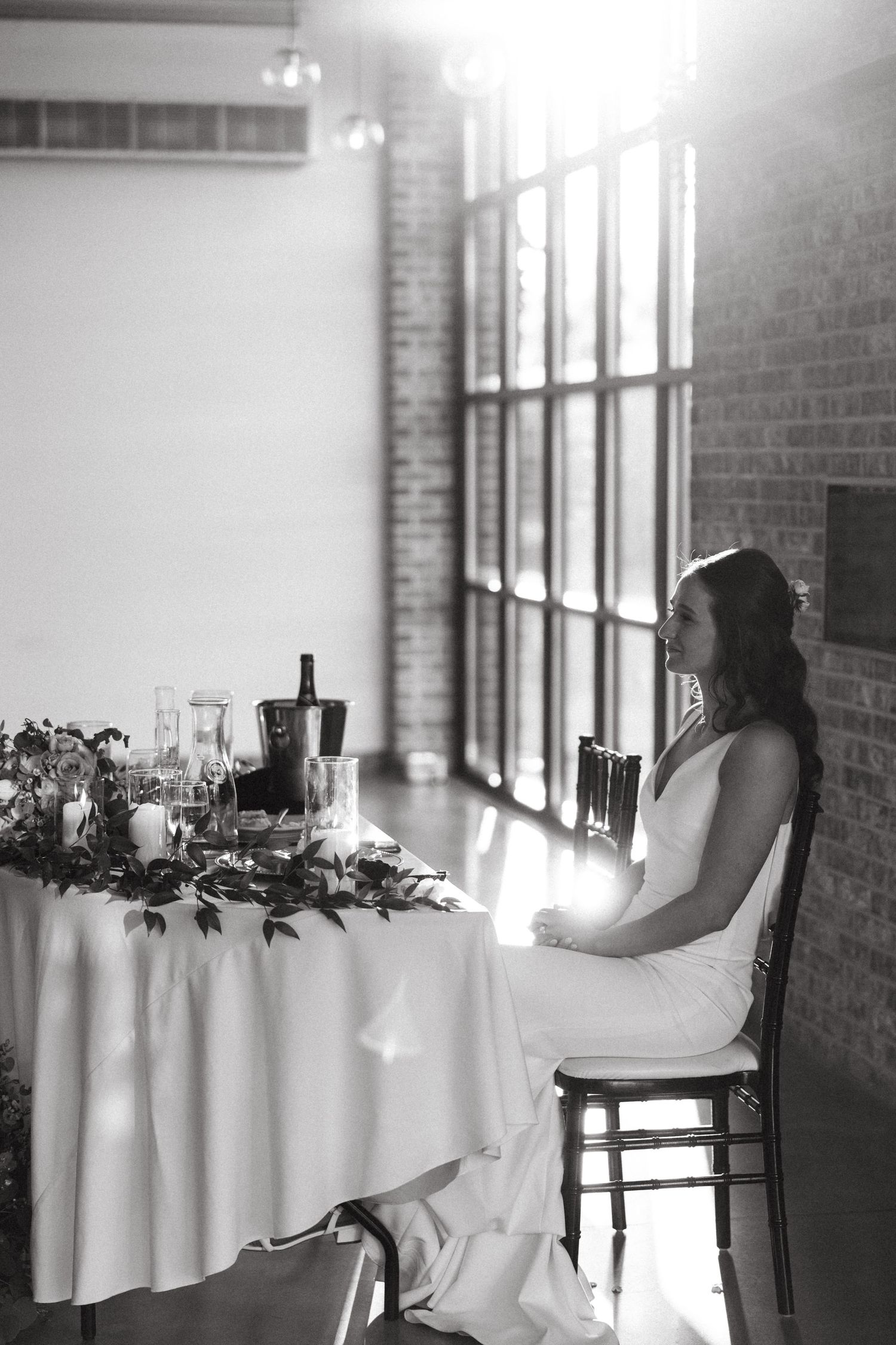 Candid moment between couple and baby in sunlit venue.