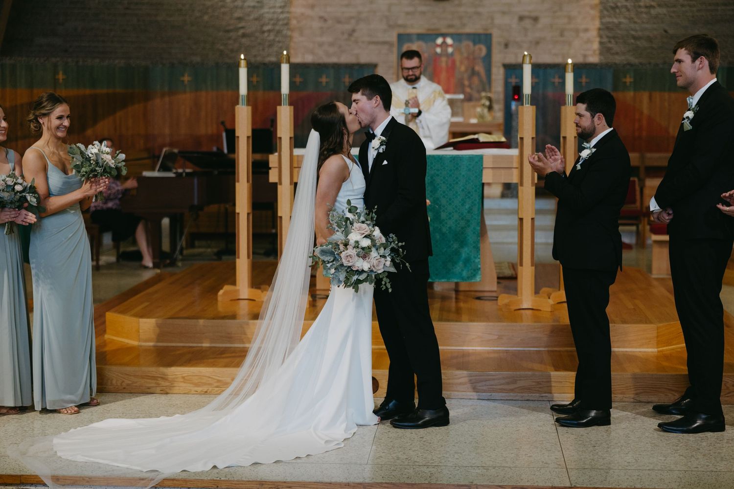 Traditional church wedding ceremony with wedding party standing at altar.