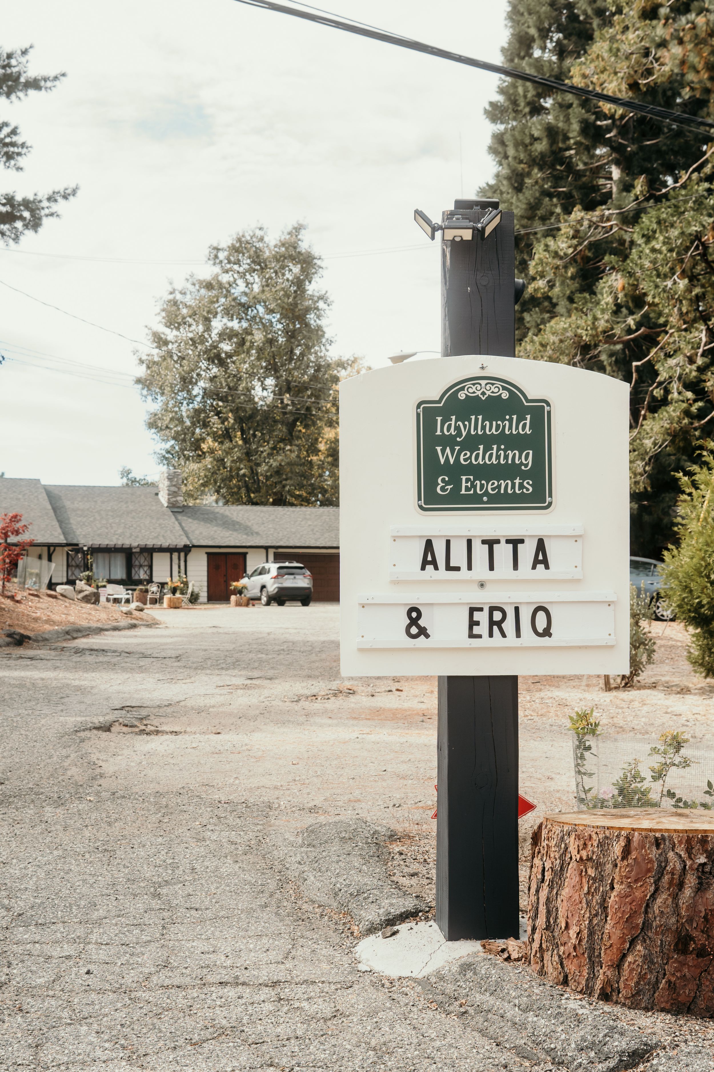 Idyllwild Wedding & Events venue sign displays names Alitta & Eriq against a rustic outdoor setting.
