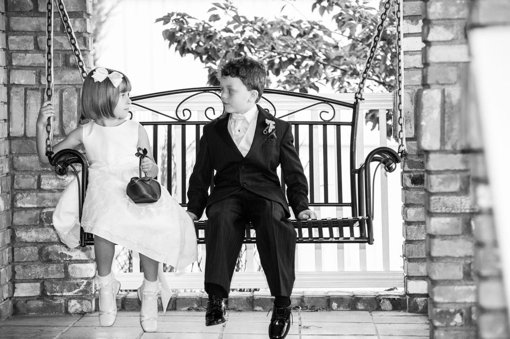 A black and white photo of two individuals walking near an iron gate.
