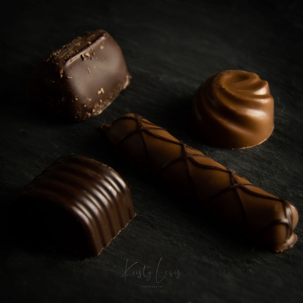 Product photography of four chocolates varying in sizing. placed on black slate.captured with studio lighting in Blackwood, South Wales
