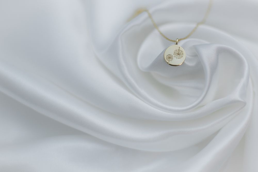 Close-up product photography of a gold chain on a white satin fabric - studio lighting, shot in Blackwood, South Wales
