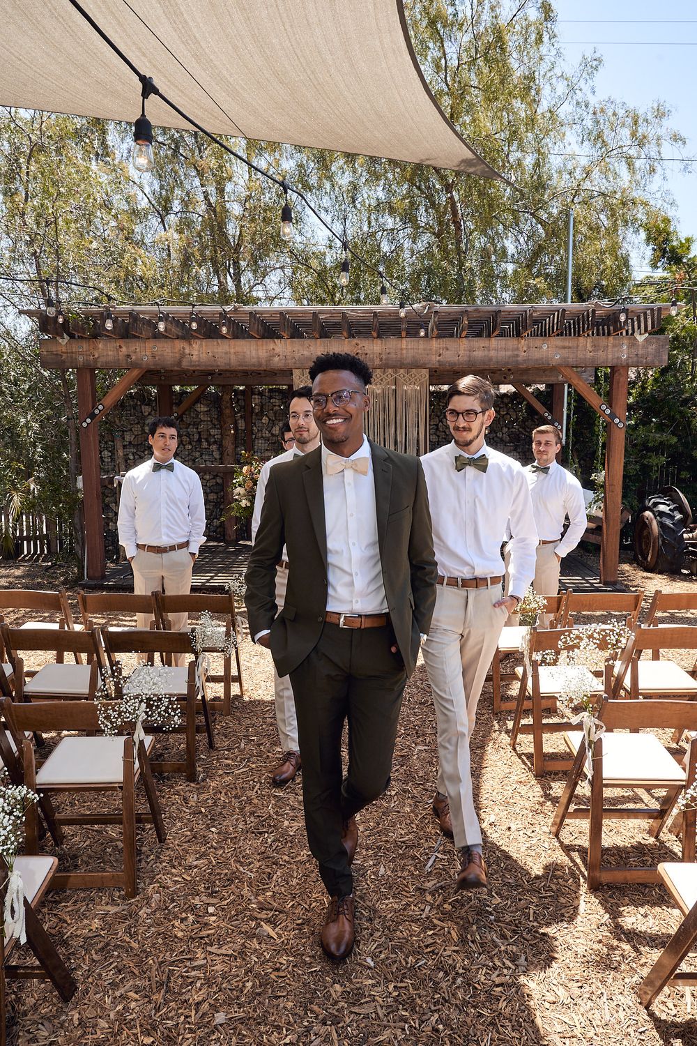 Groom and groomsmen walking in ceremony area for pictures at the Riverbed Farm in Anaheim, California.