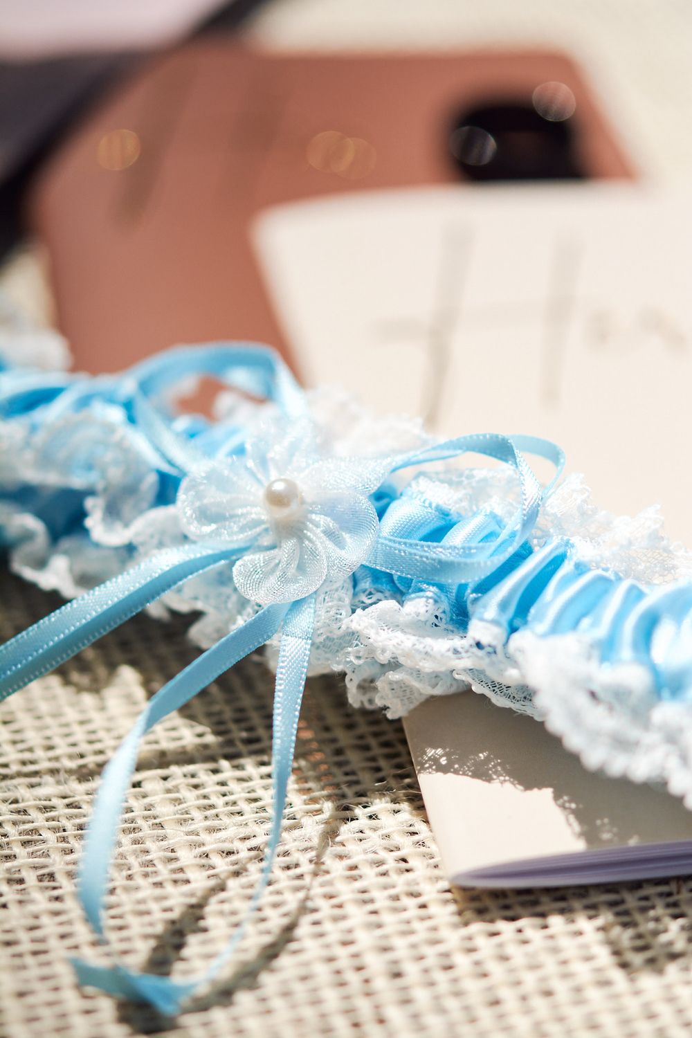 Close up detail image of the ribbon and lace on the bride's blue garter